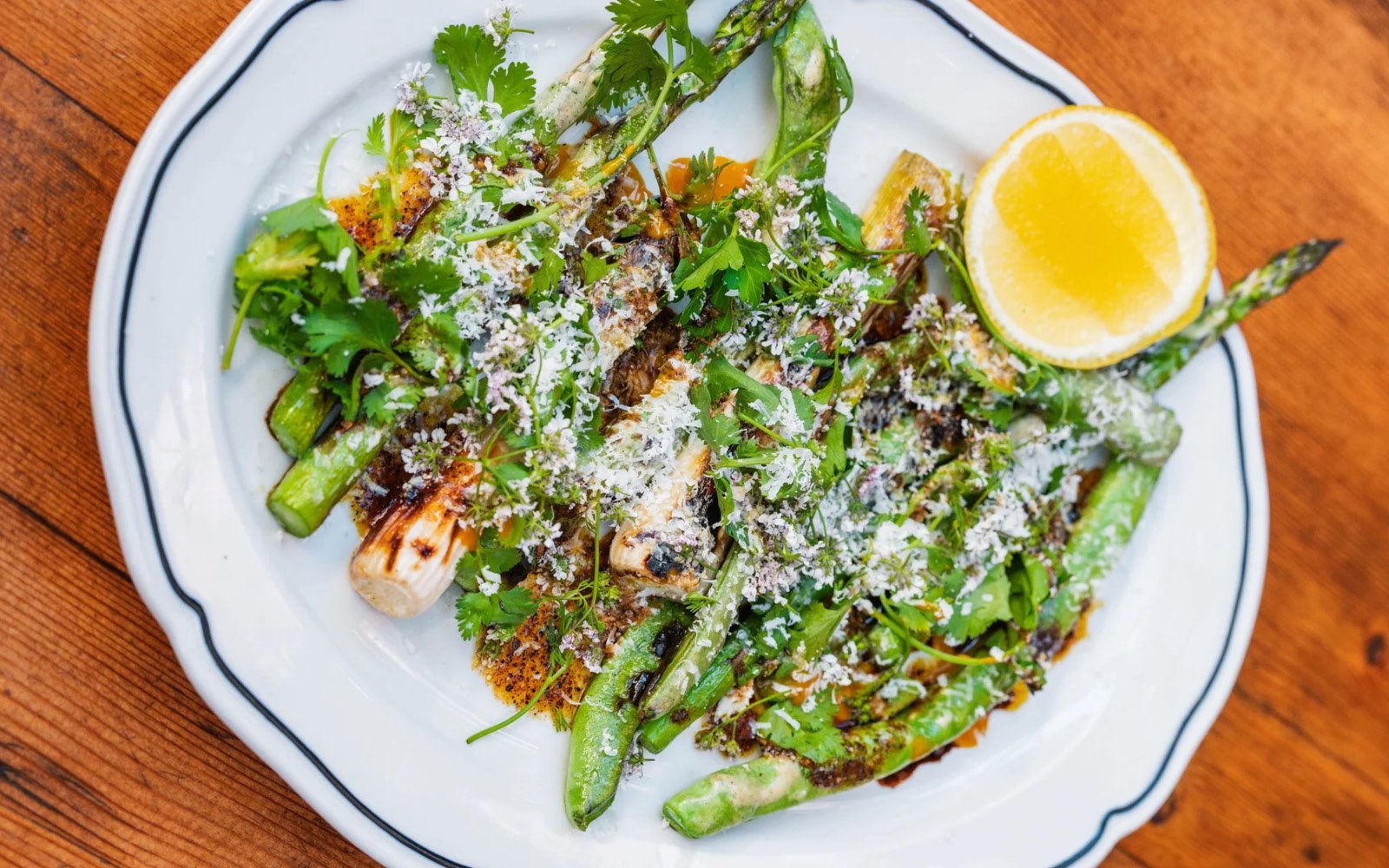  Primavera Loca: Grilled Asparagus, Dragon Tongue Beans, Spring Onions, Burnt Leek Top Mayonnaise, Salsa Negra, Housemade Mustard, Queso Duro, Annatto-Chile Oil, Cilantro, Parsley, Cilantro Blossoms, Lemon Wedge 