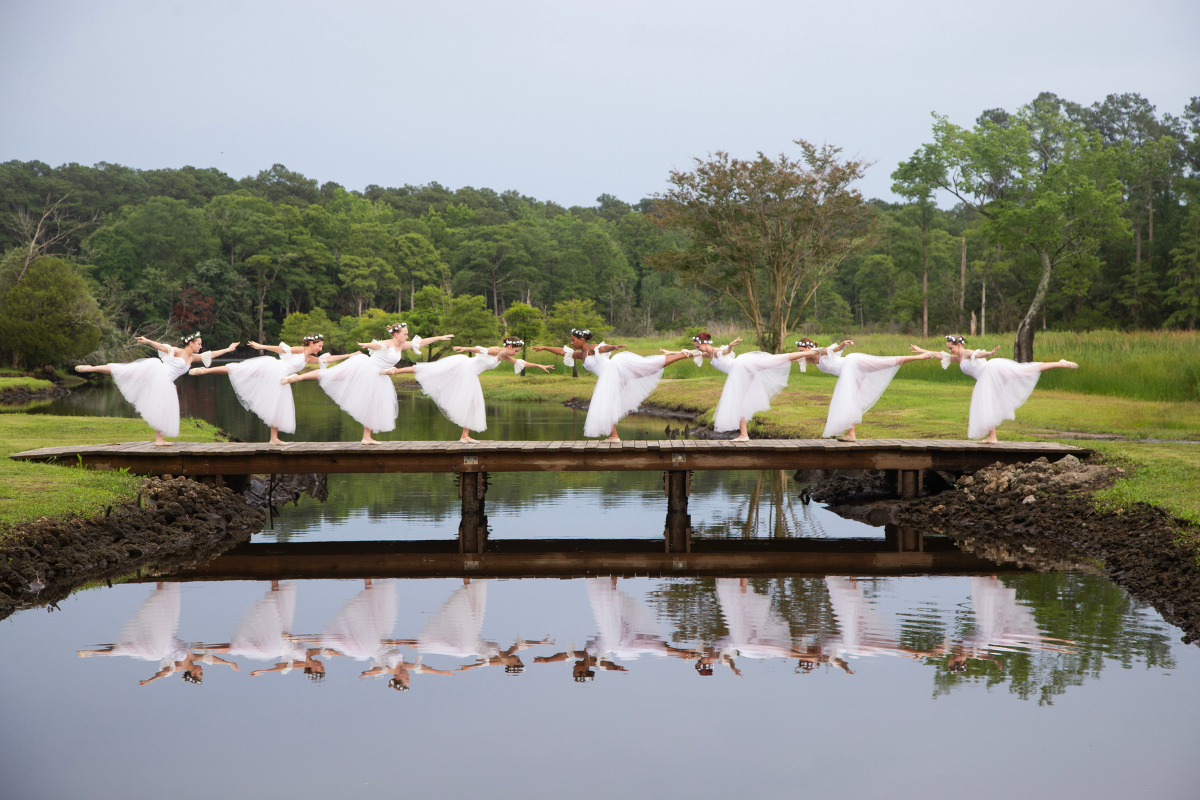 ballerinas on bridge with reflection in water
