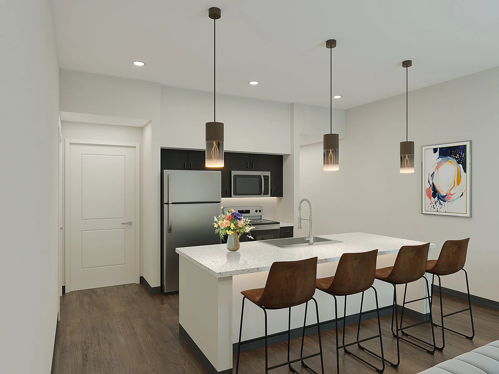 Modern kitchen with a white island counter, four bar stools, black cabinetry, stainless steel refrigerator, microwave, and oven. Pendant lights hang over the island, and a colorful abstract art piece on the wall. A vase with flowers sits on the counter.