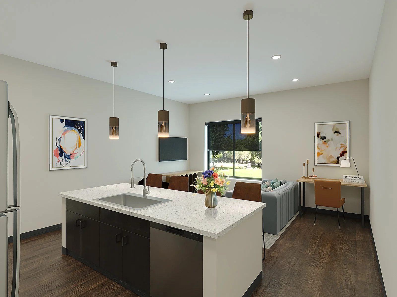 Open-concept living space with a kitchen island, hanging pendant lights, a sitting area with chairs and a sofa, wall art, a window with a view outside, and a small desk with decorative items.