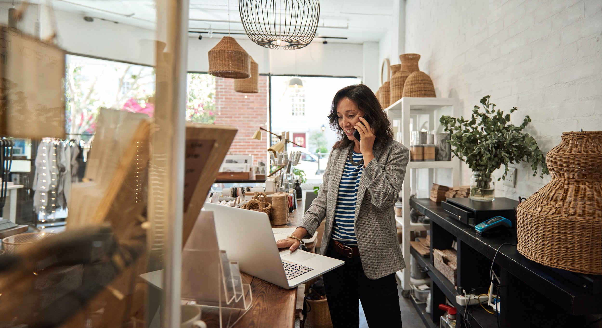 Smiling woman talking on a cellphone in her store.jpeg