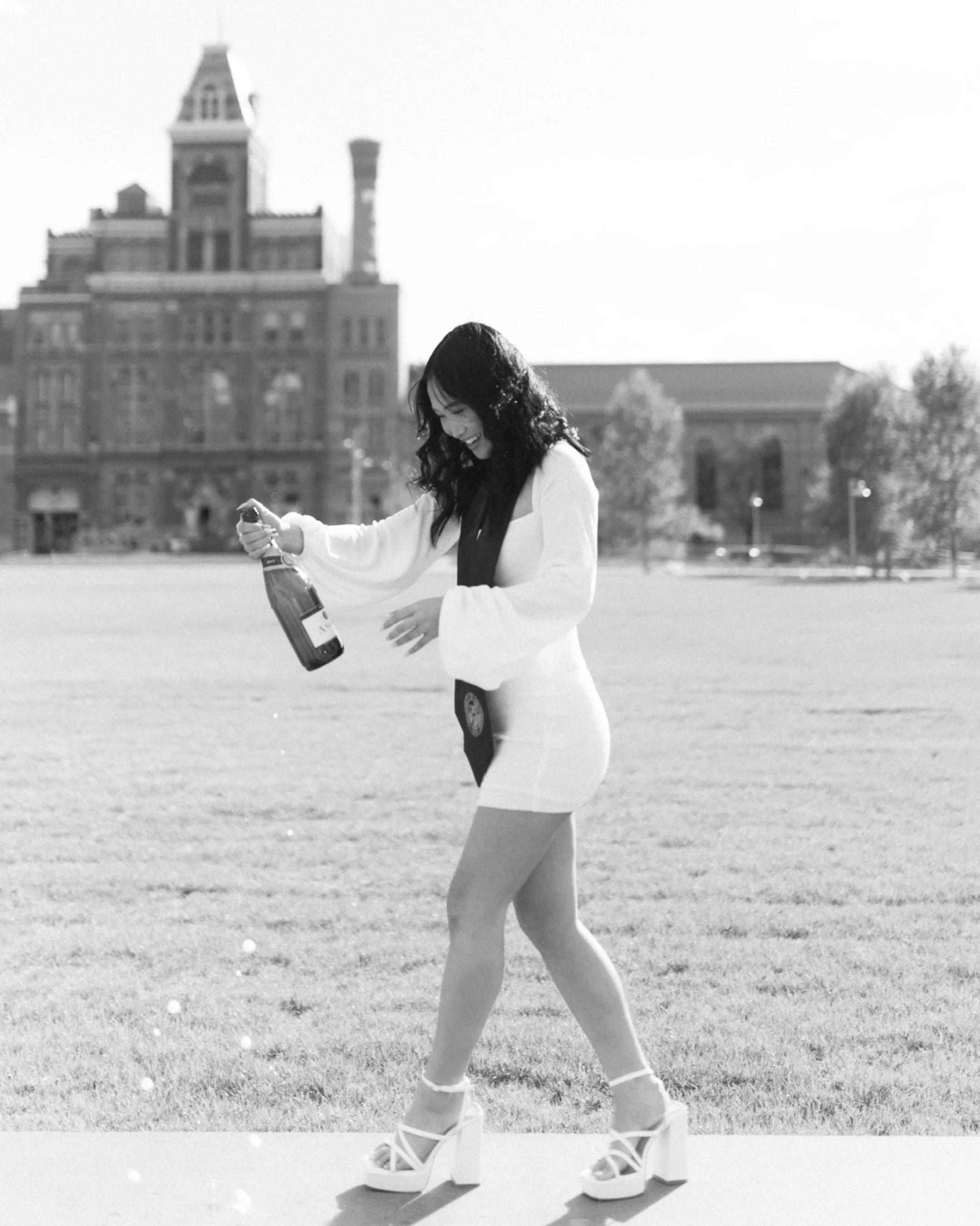 Metropolitan State University of Denver graduate celebrating with a champagne pop during a graduation photo session