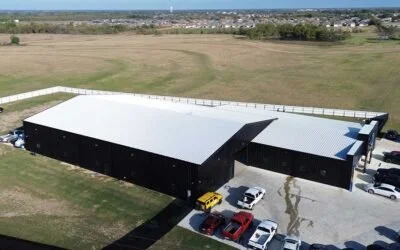 A large industrial building with a white roof and black exterior walls built by HCW.