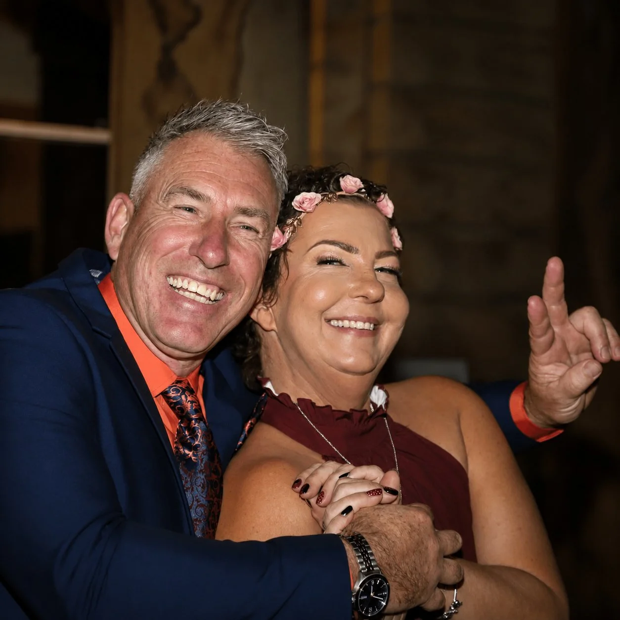 A man and woman smiling and posing for a photo at a celebration.