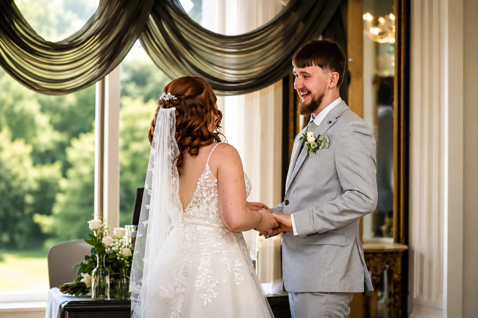 Bride and groom holding hands during wedding ceremony inside a decorated venue with large window and green outdoor scenery visible