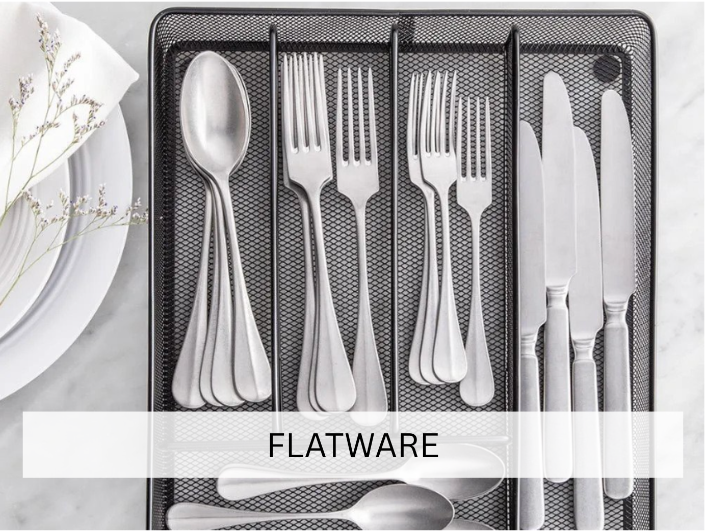 Silver cutlery neatly arranged in a drawer organizer, displaying knives, forks, and spoons in an orderly manner. This clean and modern presentation is ideal for upscale dining events.