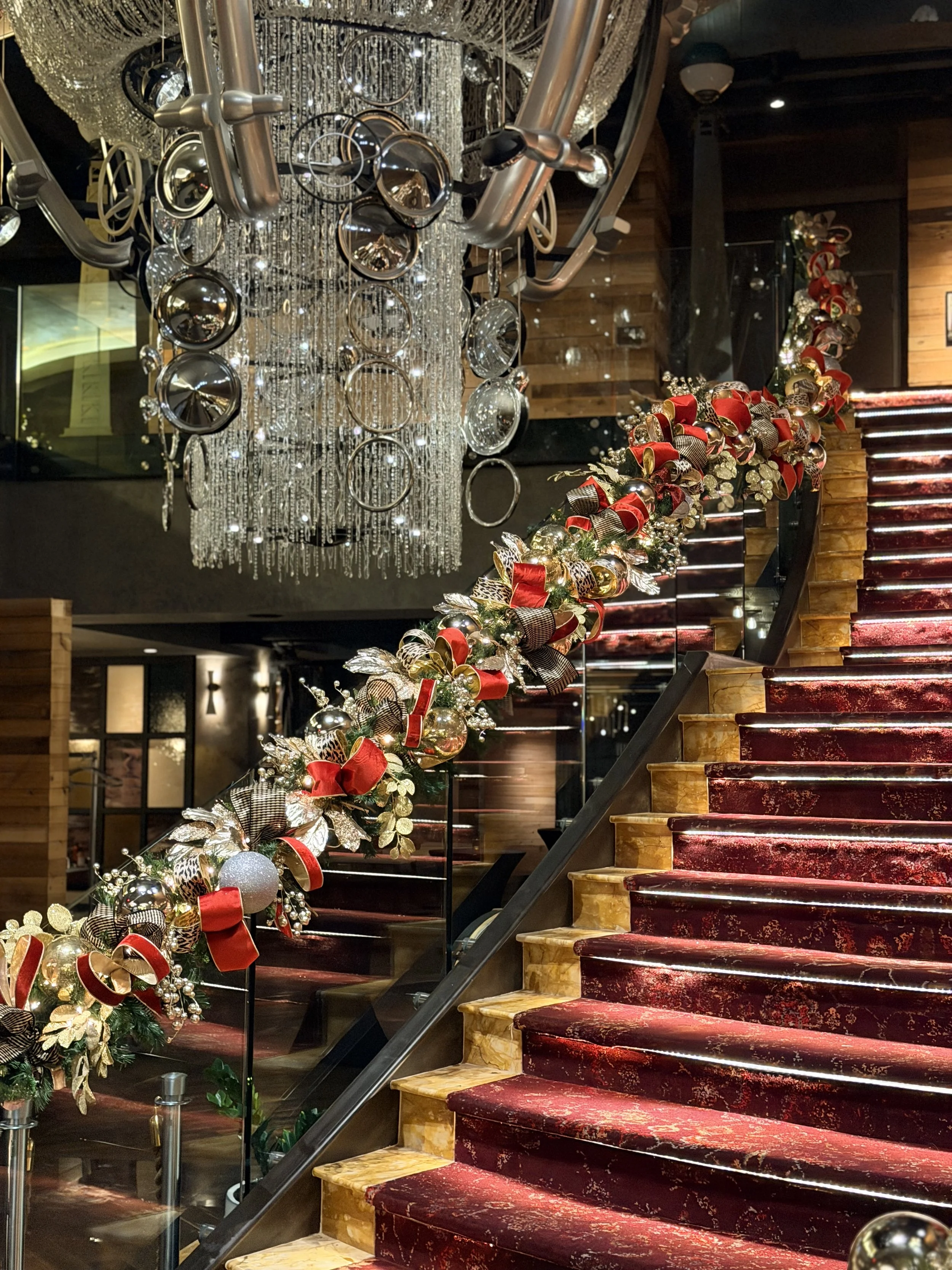 Luxury holiday garland cascading along the grand staircase at Bobby Hotel Nashville, designed by Whitney Elaine Interiors with custom ornaments, ribbon, and festive lighting.