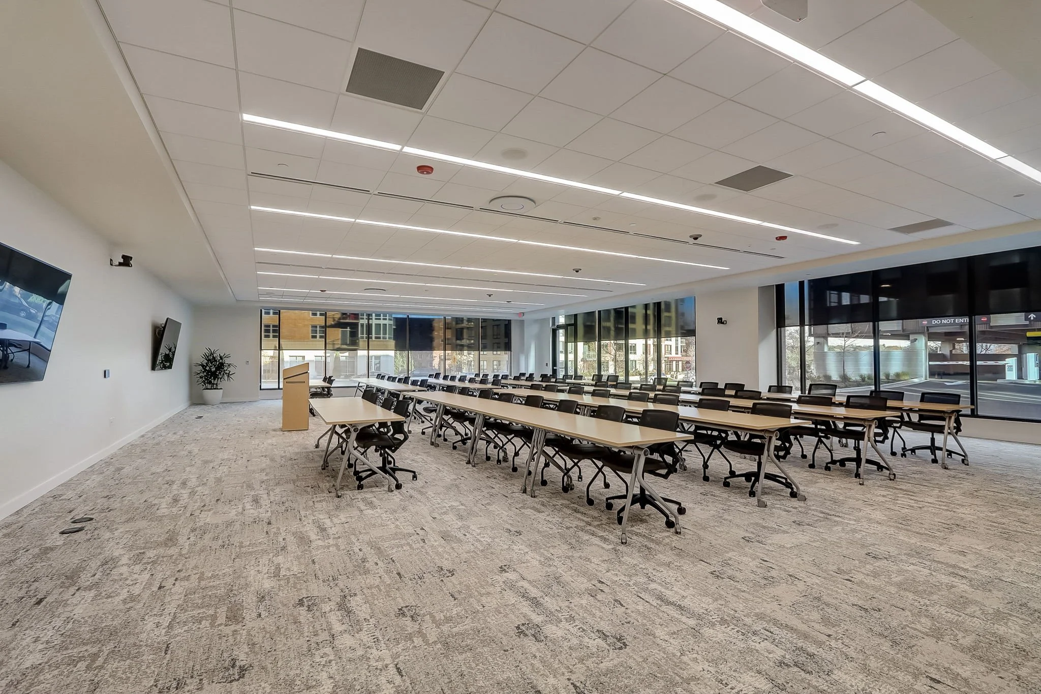 Modern conference room with tables, chairs, and large windows.