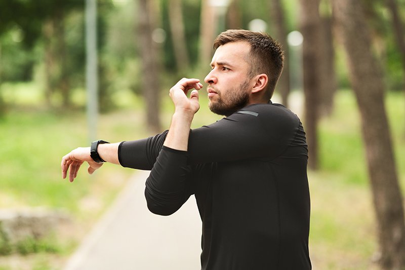 Man performing a forearm stretching exercise to reduce elbow stiffness and improve flexibility