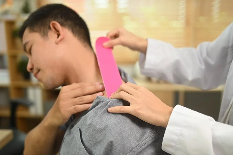 Physiotherapist providing hands-on assessment for neck and shoulder pain in a clinic setting