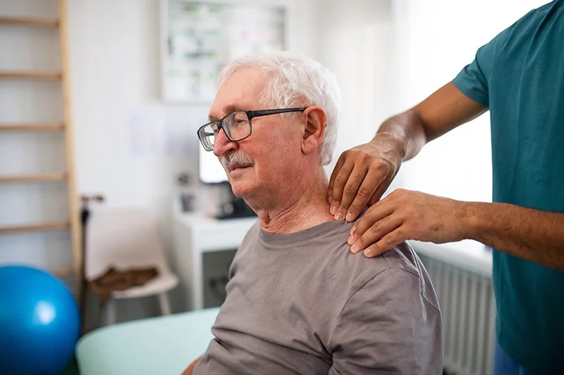 Physiotherapist assessing neck and shoulder movement during a clinical examination