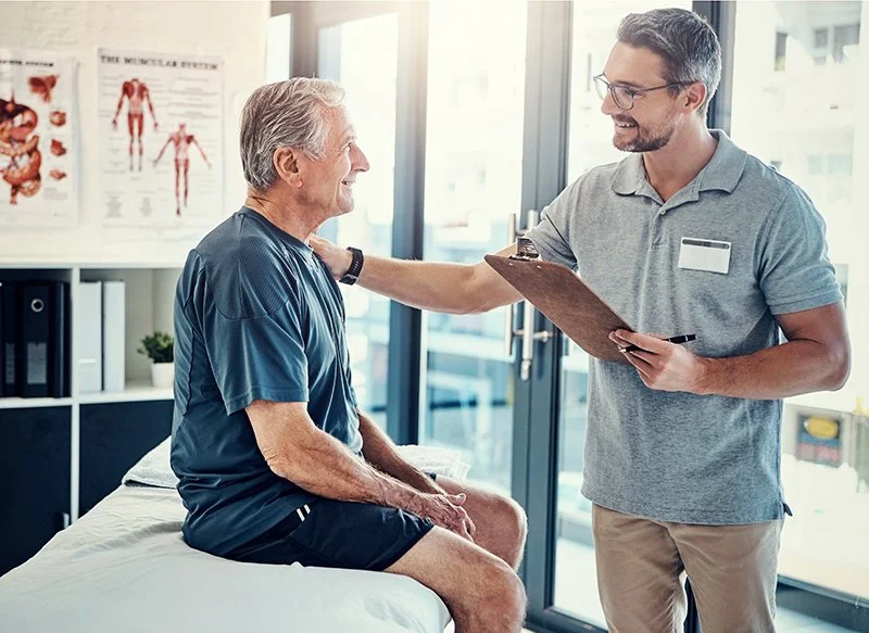 Physiotherapist discussing a rehabilitation plan with a patient during a clinic consultation