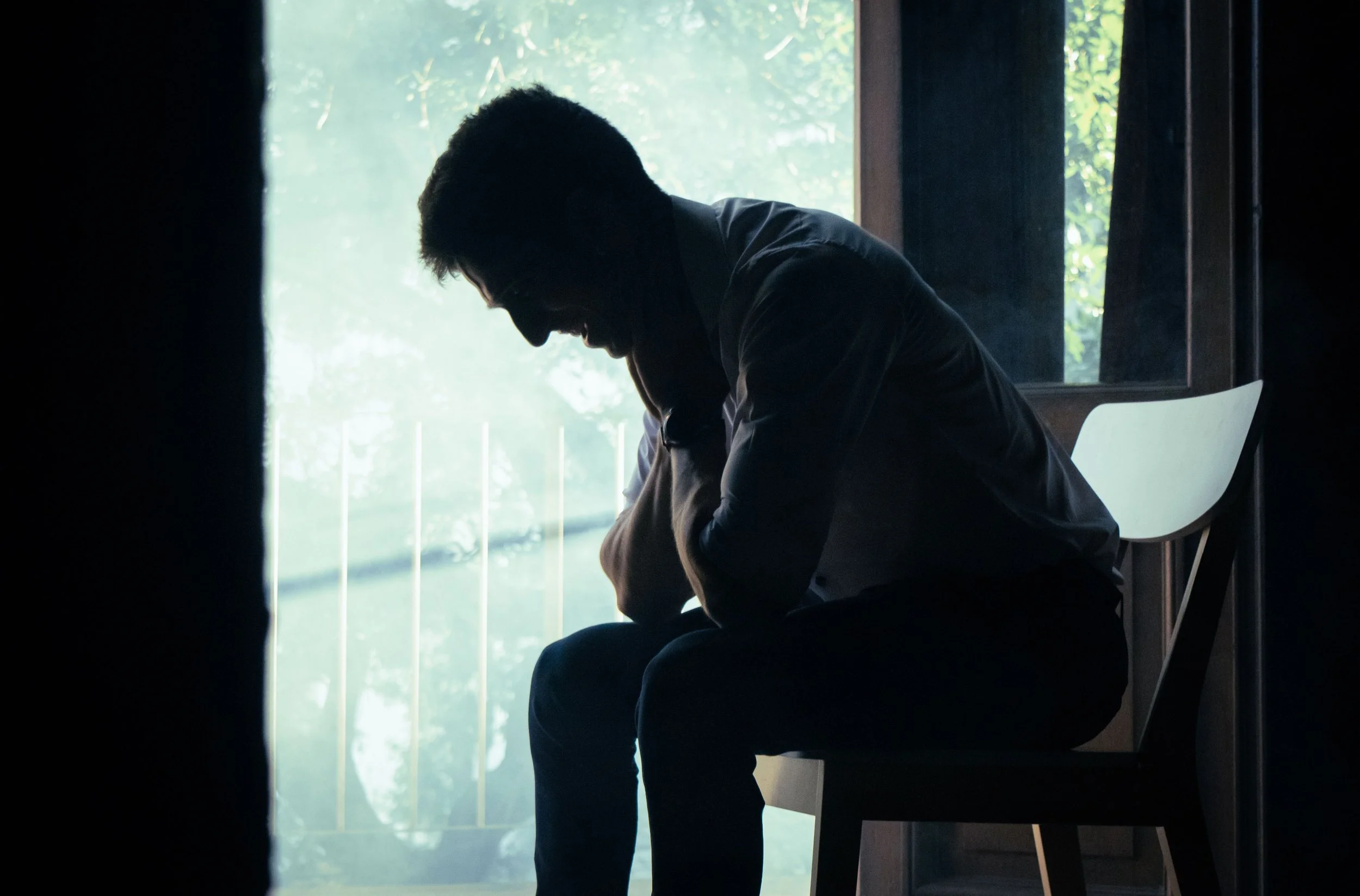 A veteran sitting quietly on a porch at dusk on the Fourth of July.