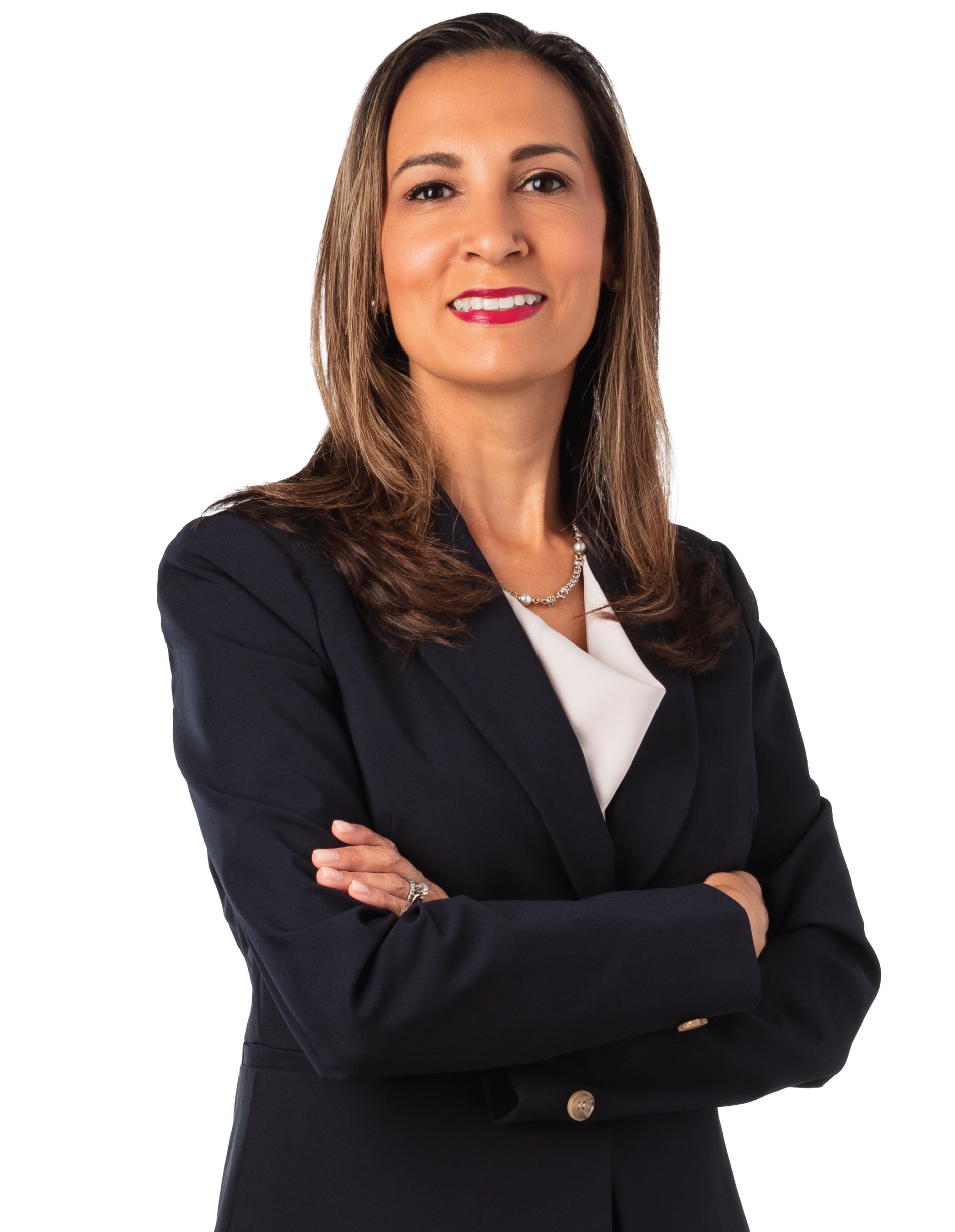 A professional woman with light skin, long brown hair, wearing a dark blazer and a pearl necklace, smiling with arms crossed against a white background.