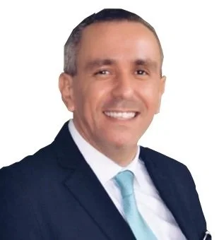 Professional headshot of a smiling man in a dark suit, white shirt, and light blue tie.