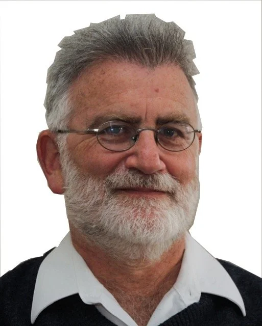 Image of a white man with grey hair, a white beard and glasses with a white shirt and dark sweater.