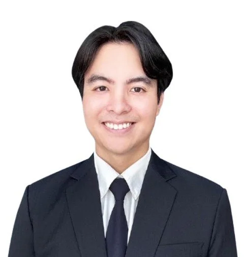 Professional image of a smiling man with dark hair wearing a white shirt with a black jacket and tie