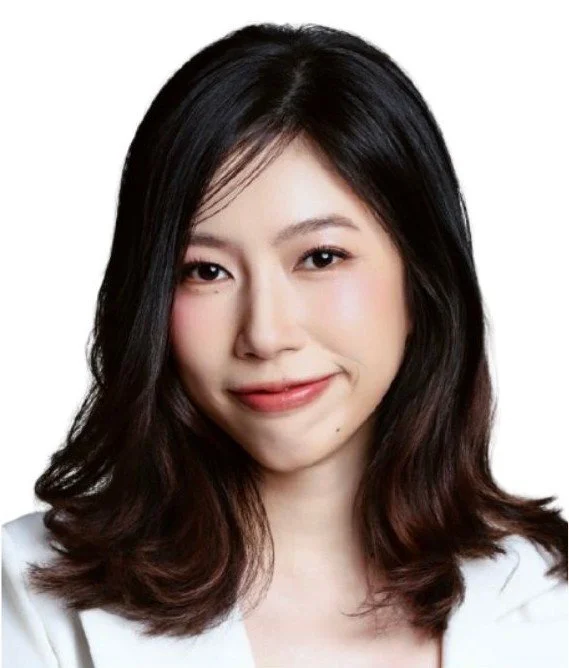 A woman with black hair wearing a black blazer and a white shirt against a white background.