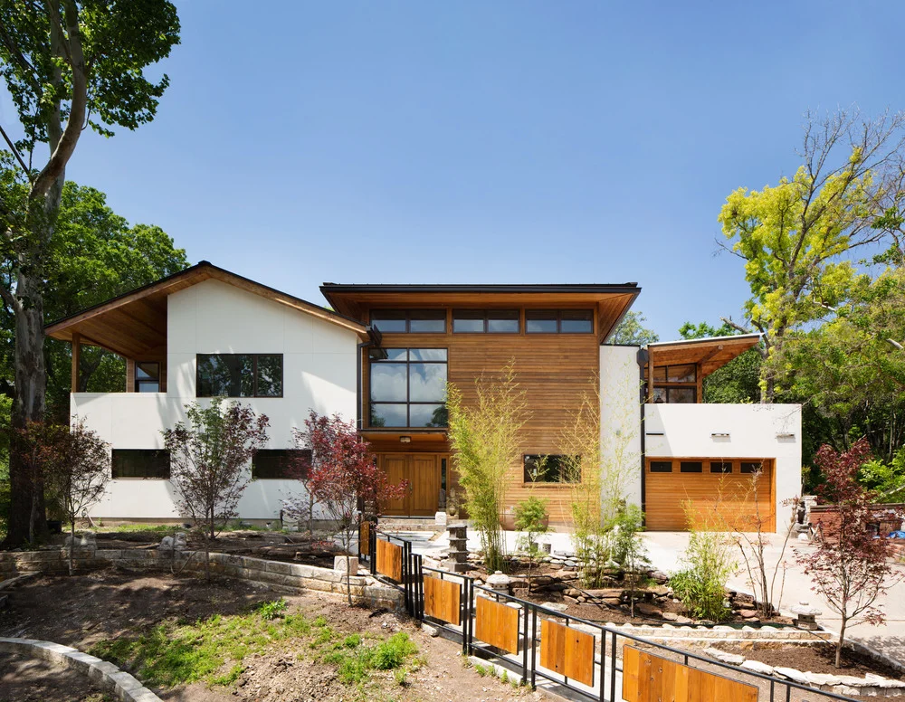 Westview residence by Forsite Studio — white and wood exterior with two-car garage and landscaped front yard — Austin, TX
