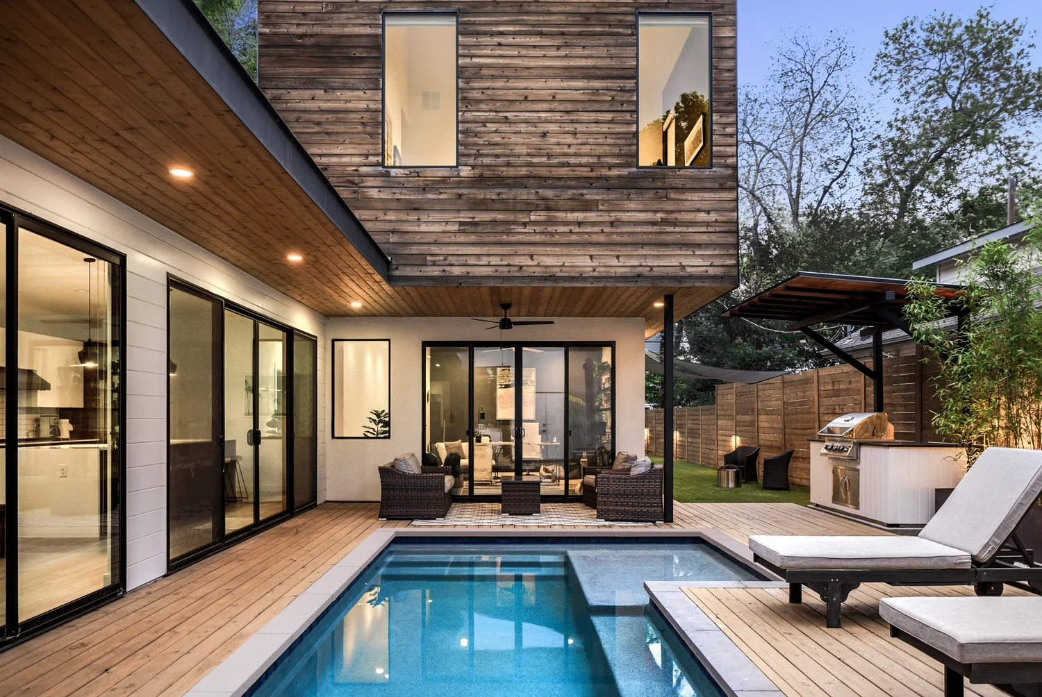 Rio Vista residence by Forsite Studio — pool and outdoor grill area with wood fence and tropical landscaping — Austin, TX