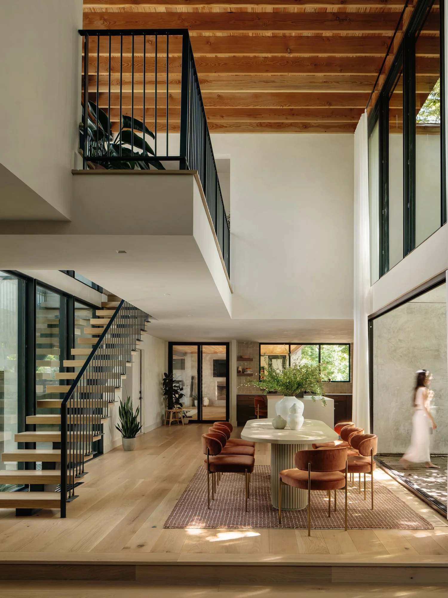 Camp Koko residence by Forsite Studio — open dining room with double-height staircase and tree canopy views — Austin, TX