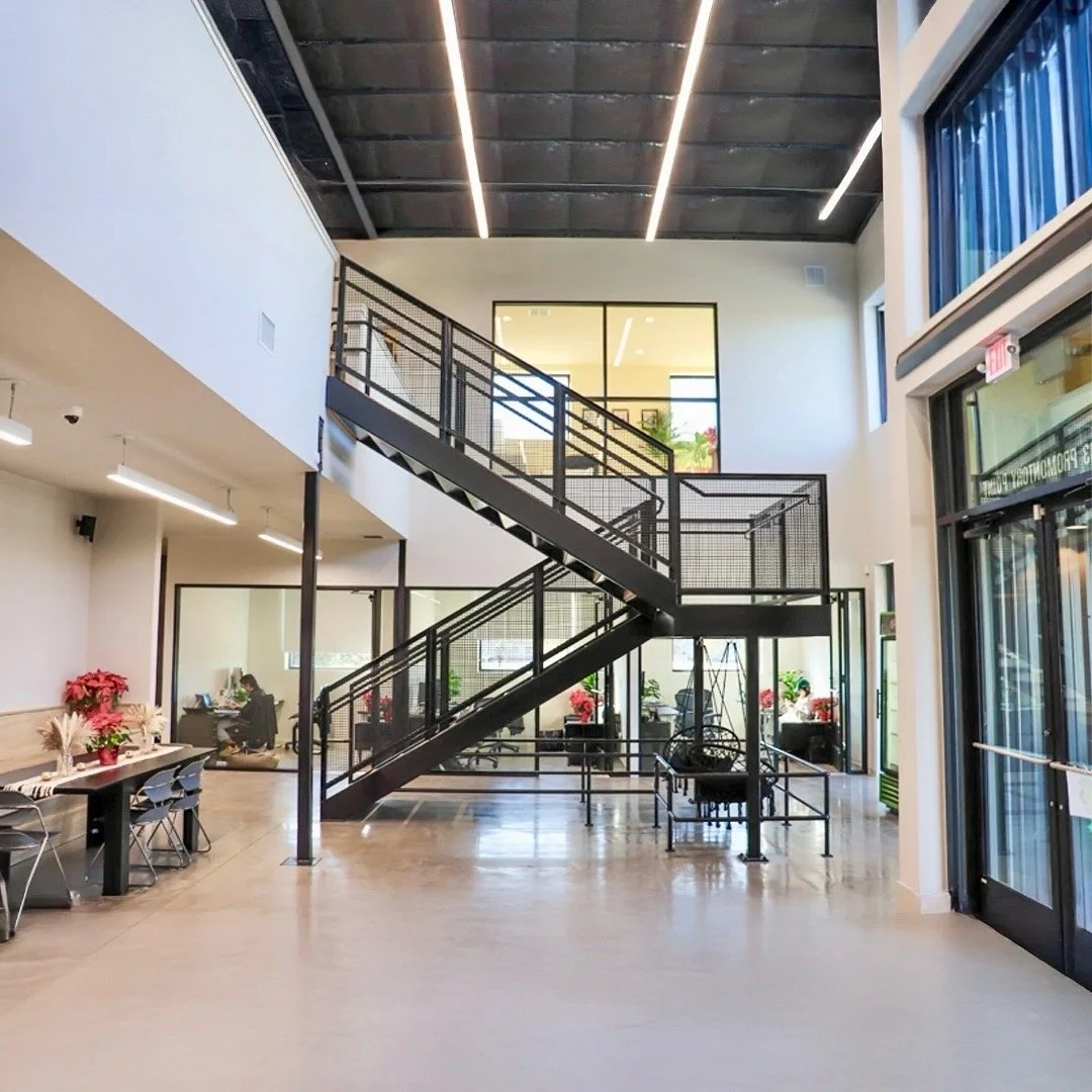 HighFive commercial project by Forsite Studio — open interior staircase with glass windows and office spaces decorated with holiday plants — Austin, TX