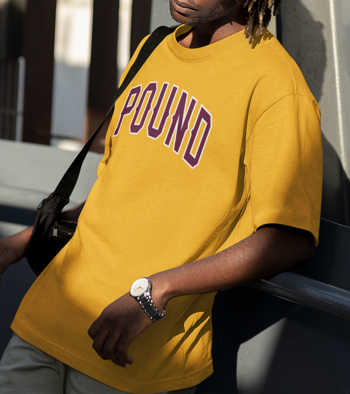 A man wearing a Garment-washed gray tee by Pound Brands heavyweight cotton POUND, with burgundy and light gray accents.