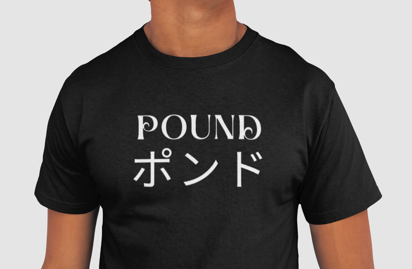 Man wearing a POUND Unisex Premium Reserved T-shirt in Black with POUND in English and Japanese. White letters across the chest. 100% Cotton Tee.