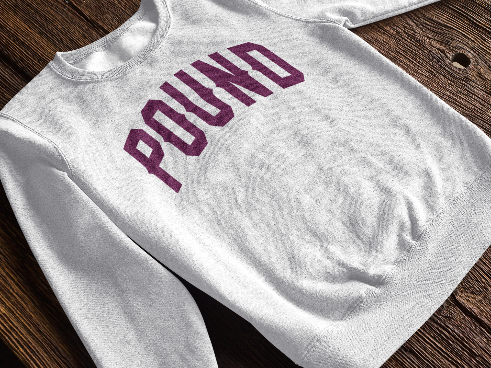 Soft crewneck sweatshirt with a bold maroon “POUND” varsity graphic. Clean, everyday fit.