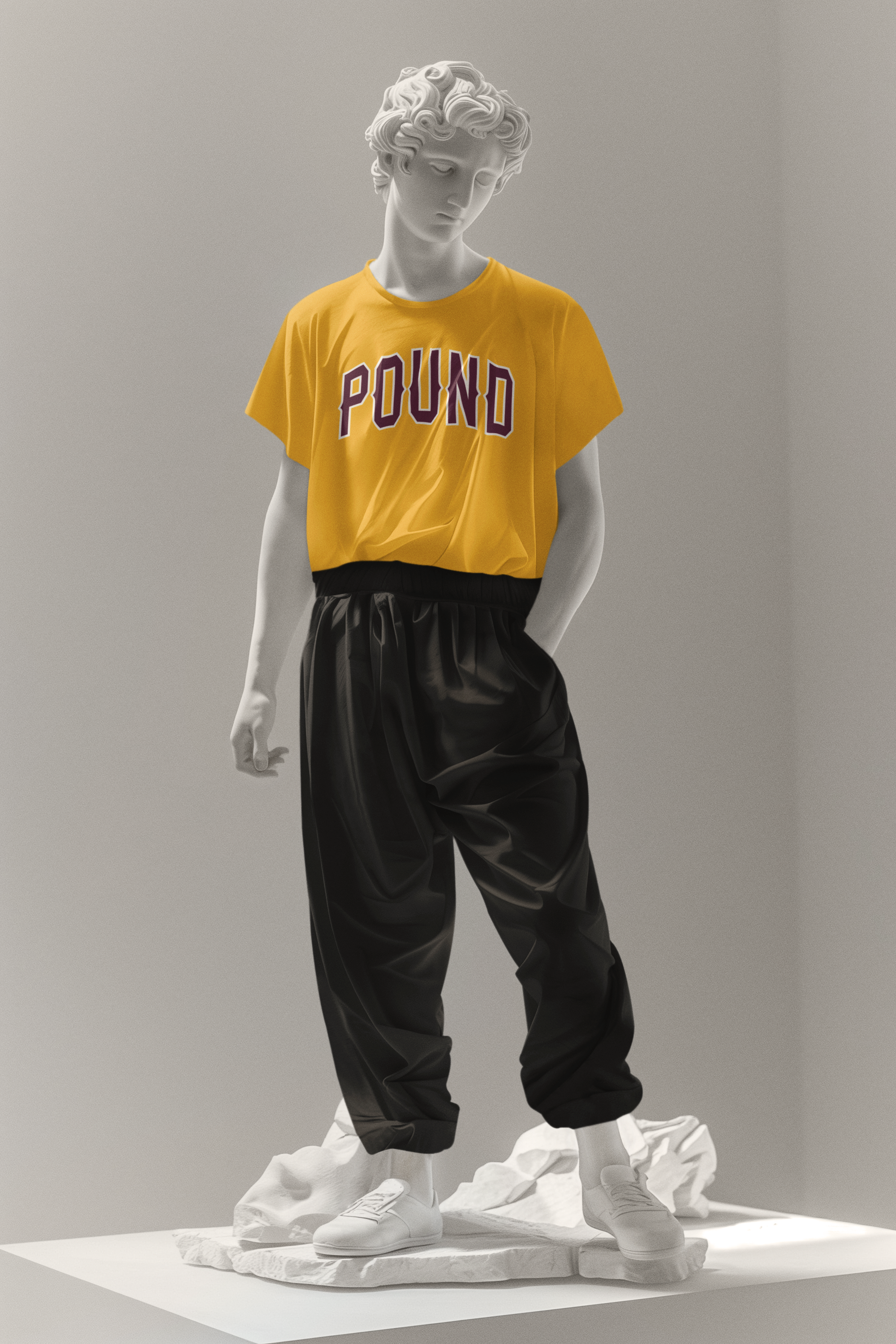 A marble statue of a young man with curly hair, wearing a yellow T-shirt with the word 'POUND' on it, black pants, and white sneakers, standing on a textured base.
