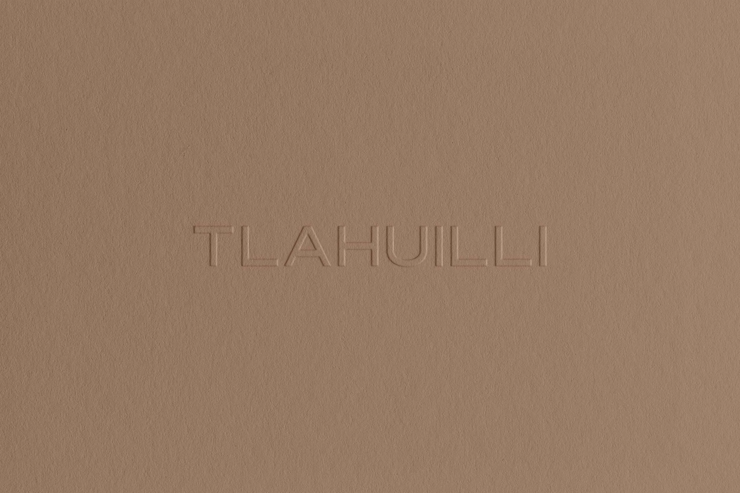 Embossed text on a beige surface reads 'TLAHULLI'.