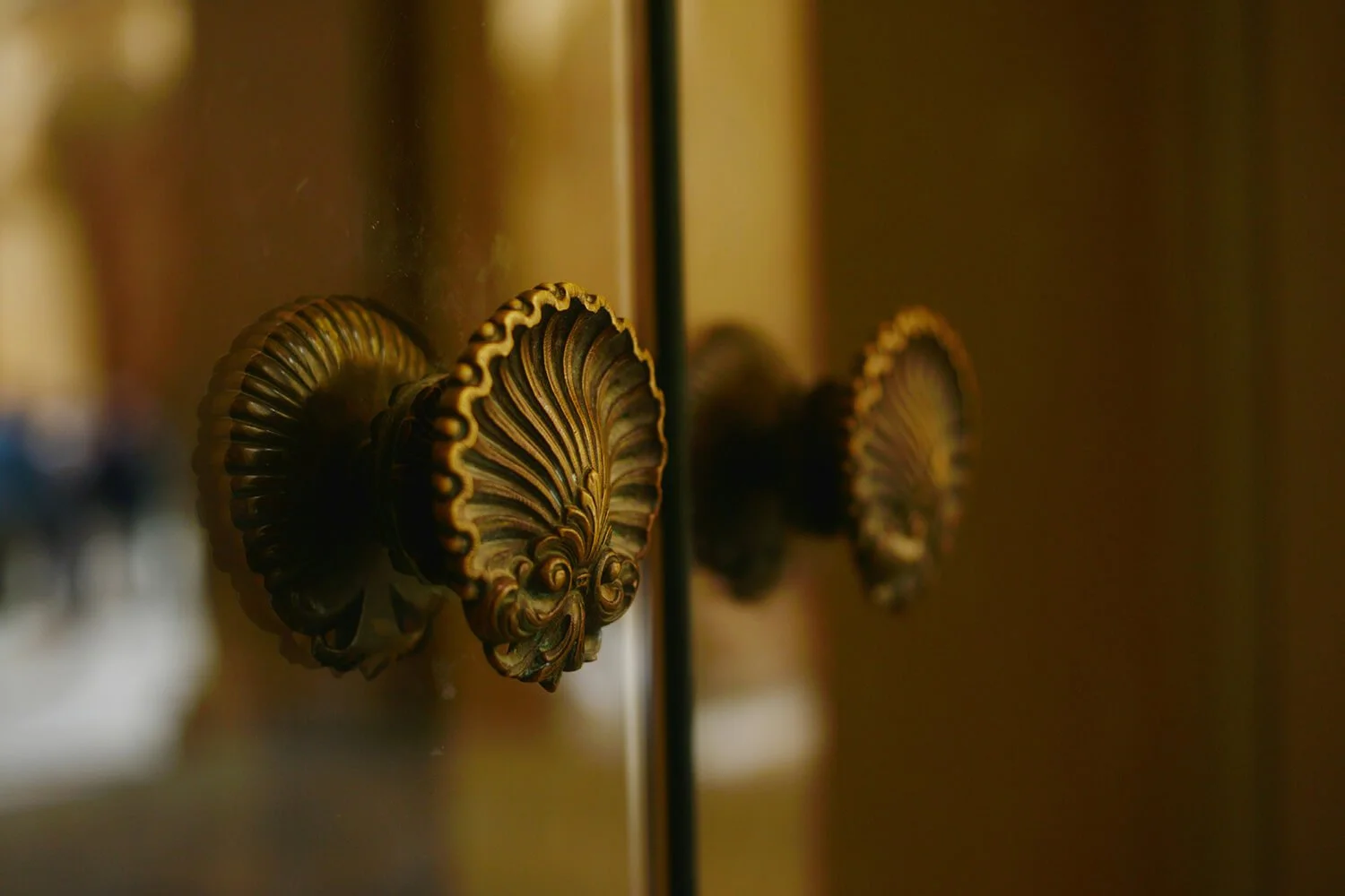 Close-up of ornate gold decorative furniture knob on a cabinet or door