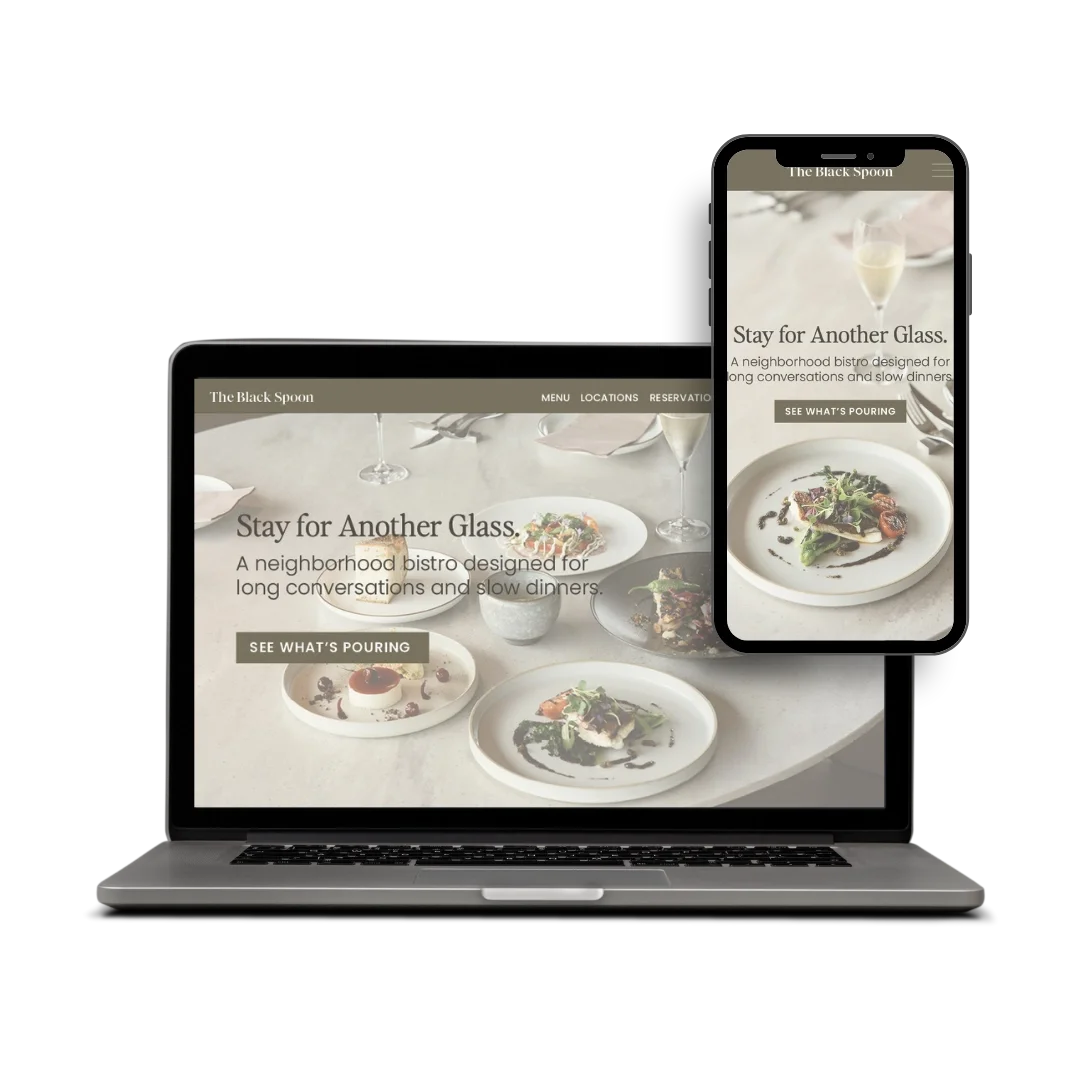Website displayed on a laptop and smartphone for The Black Spoon, a neighborhood bistro featuring plated dishes, salads, wine glasses, and a call-to-action button that says 'See What's Pouring'.
