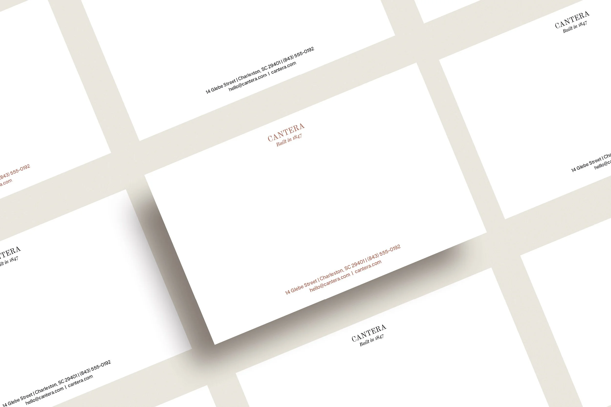 Close-up of multiple white business cards with black and red text, featuring a company's name, address, email, and the phrase "Built in 1847".