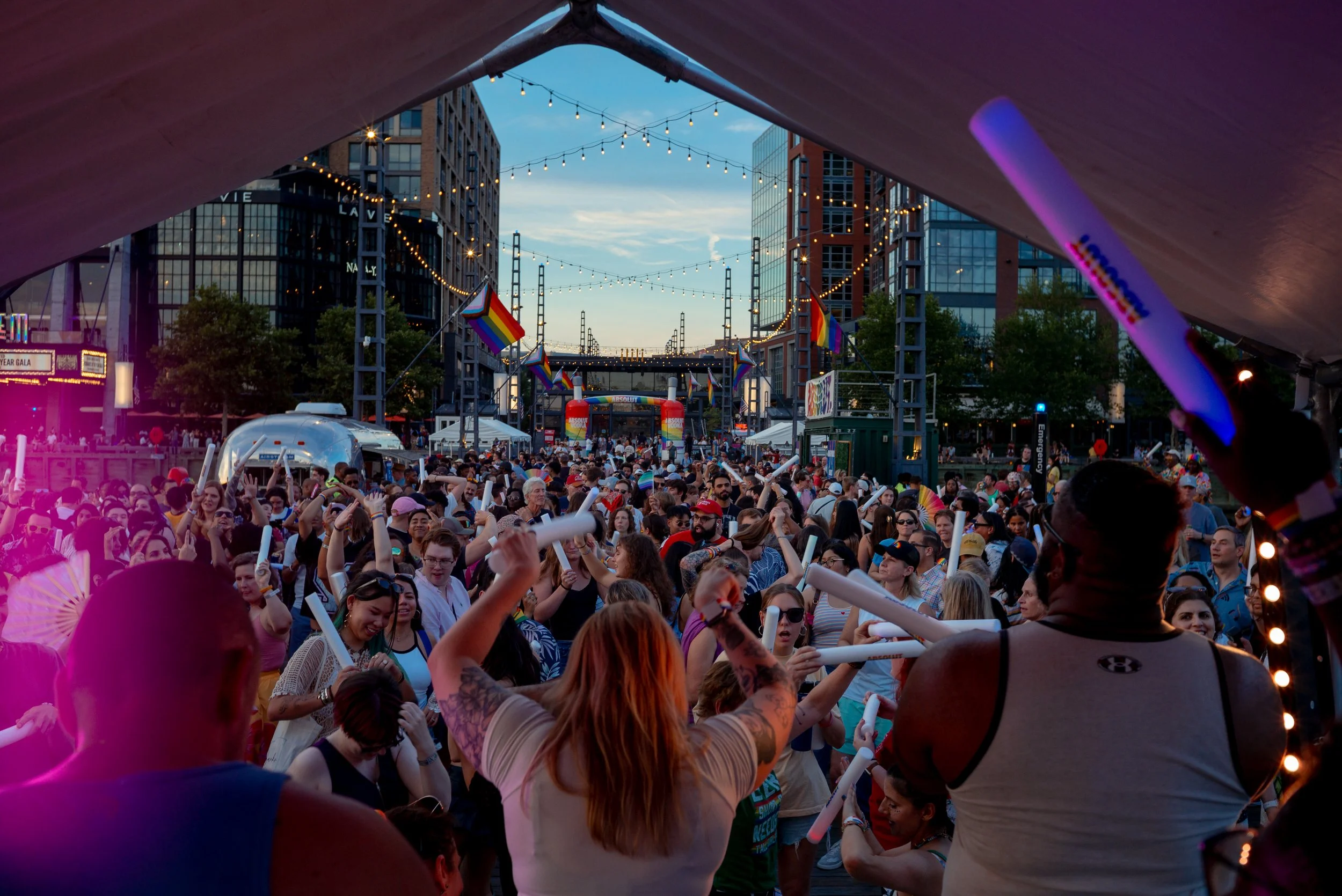 Crowds gather at Pride on the Pier in Washington, D.C., as the sun sets over the waterfront. The celebration featured live performances and community programming.