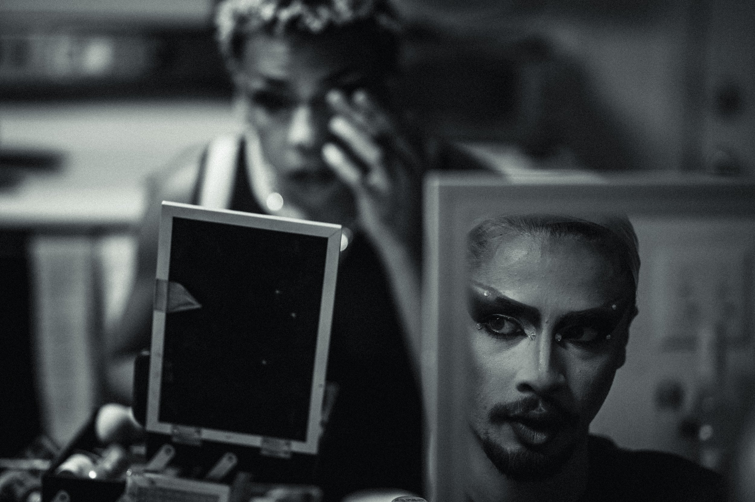 Shenandoah checks her makeup before putting on a wig.