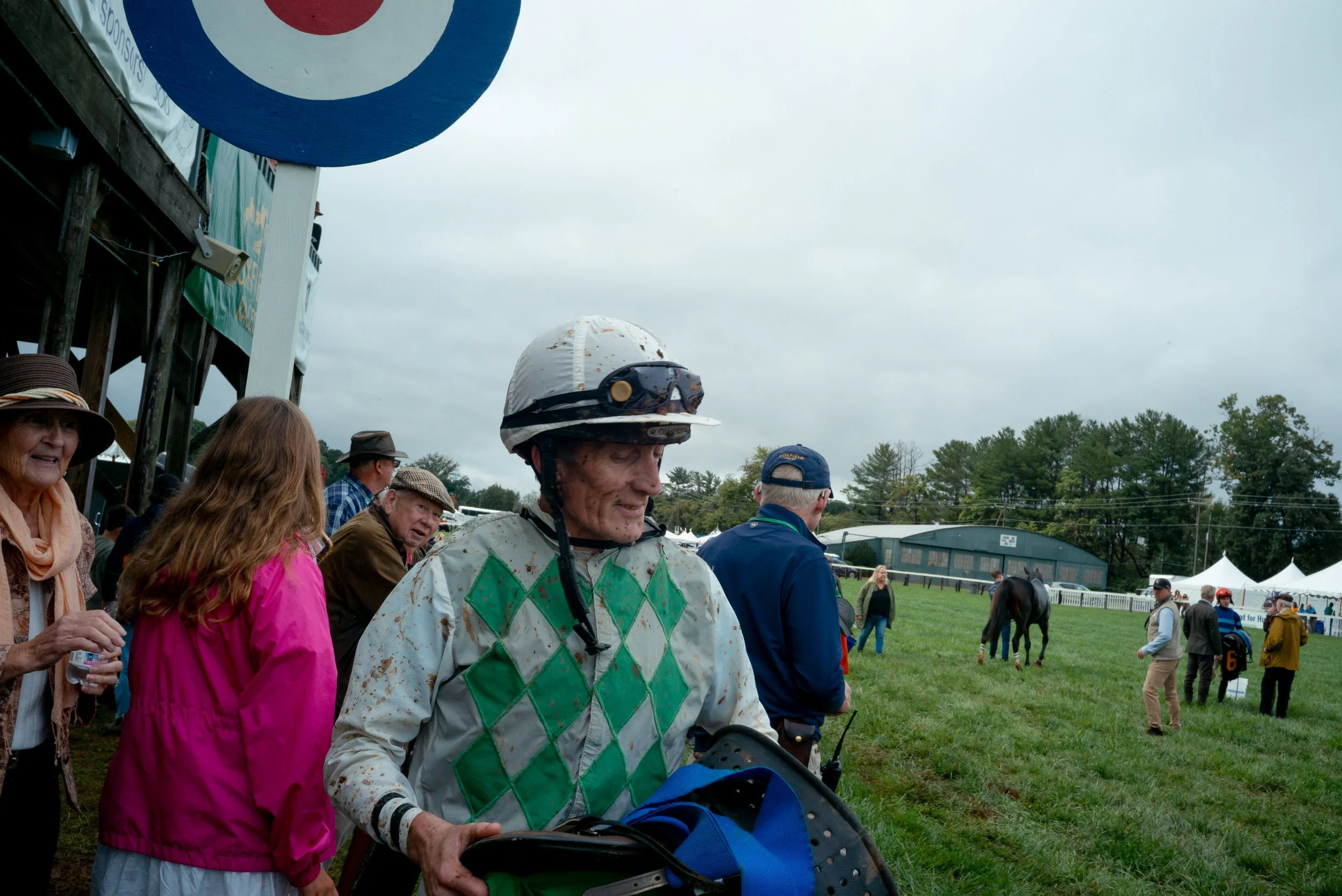 Covered in mud, rain and sweat, Jockeys remove their saddles and return to their tents to rest between races.