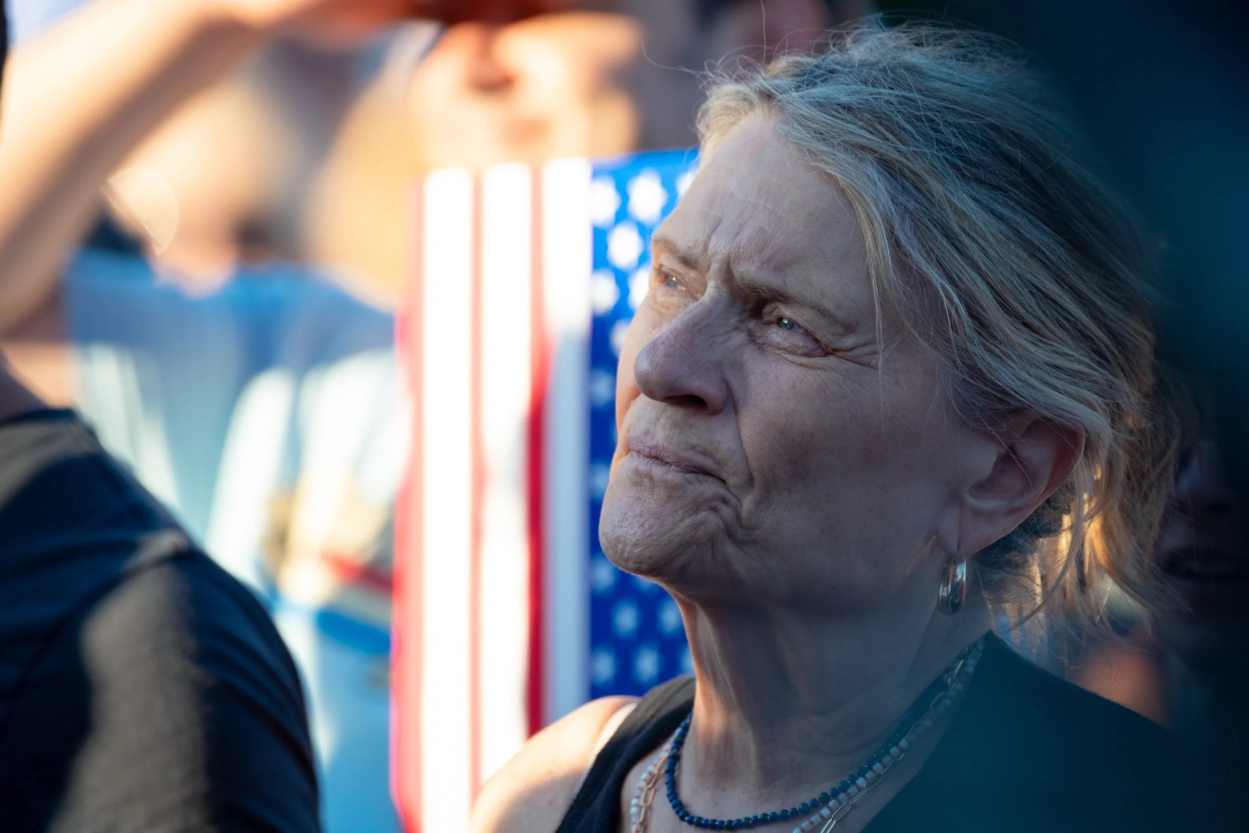 An attendee looks toward President Donald Trump as he speaks during the kickoff of the Great American State Fair in Des Moines, Iowa, on June 24, 2026. Thousands gathered for the event celebrating the nation's upcoming 250th anniversary.
