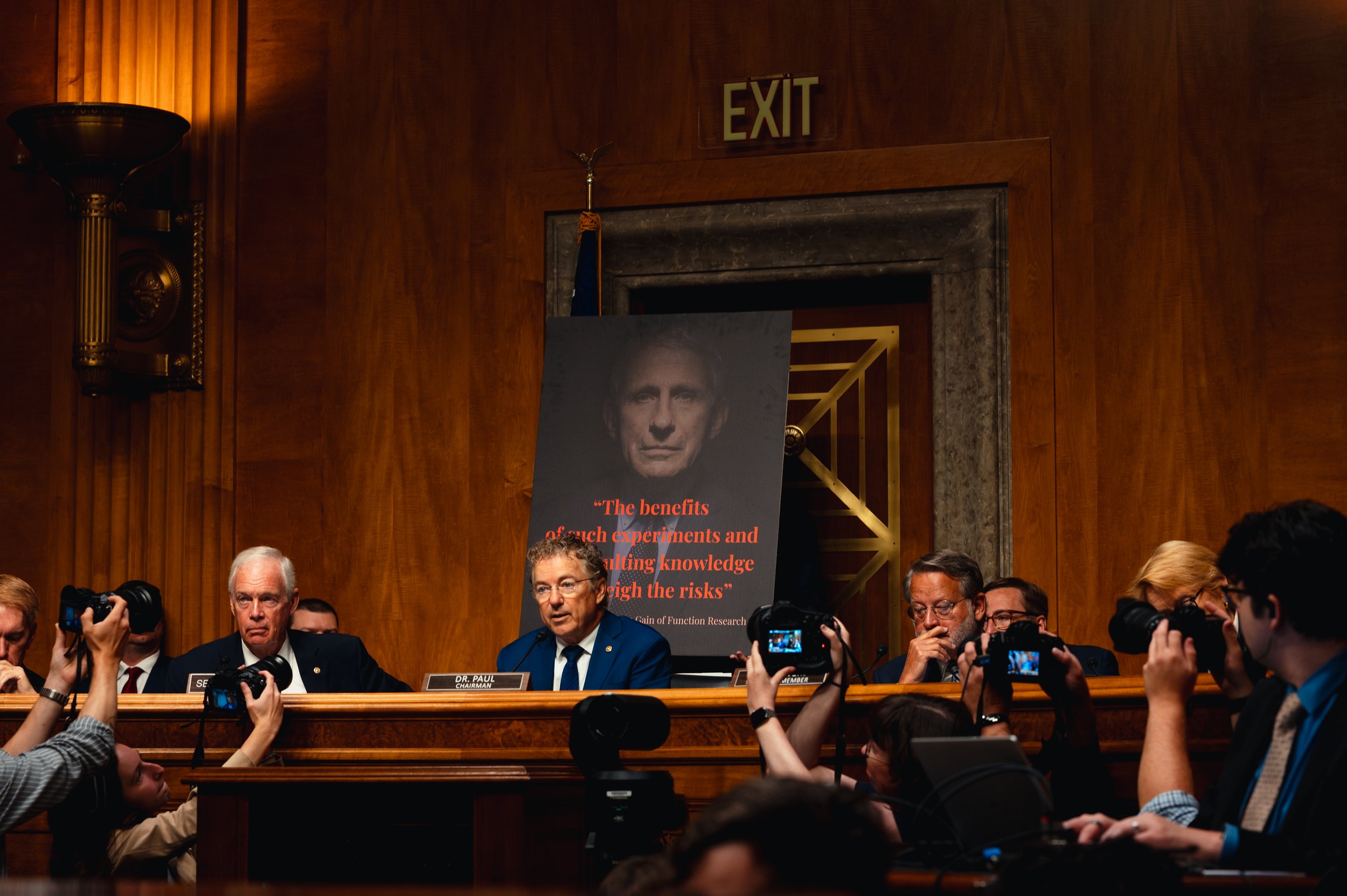 Sen. Rand Paul (R-Ky.) questions Dr. Anthony Fauci during a Senate Homeland Security and Governmental Affairs Committee hearing on Capitol Hill in Washington, Wednesday, July 29, 2026, as a poster featuring Fauci is displayed behind him.