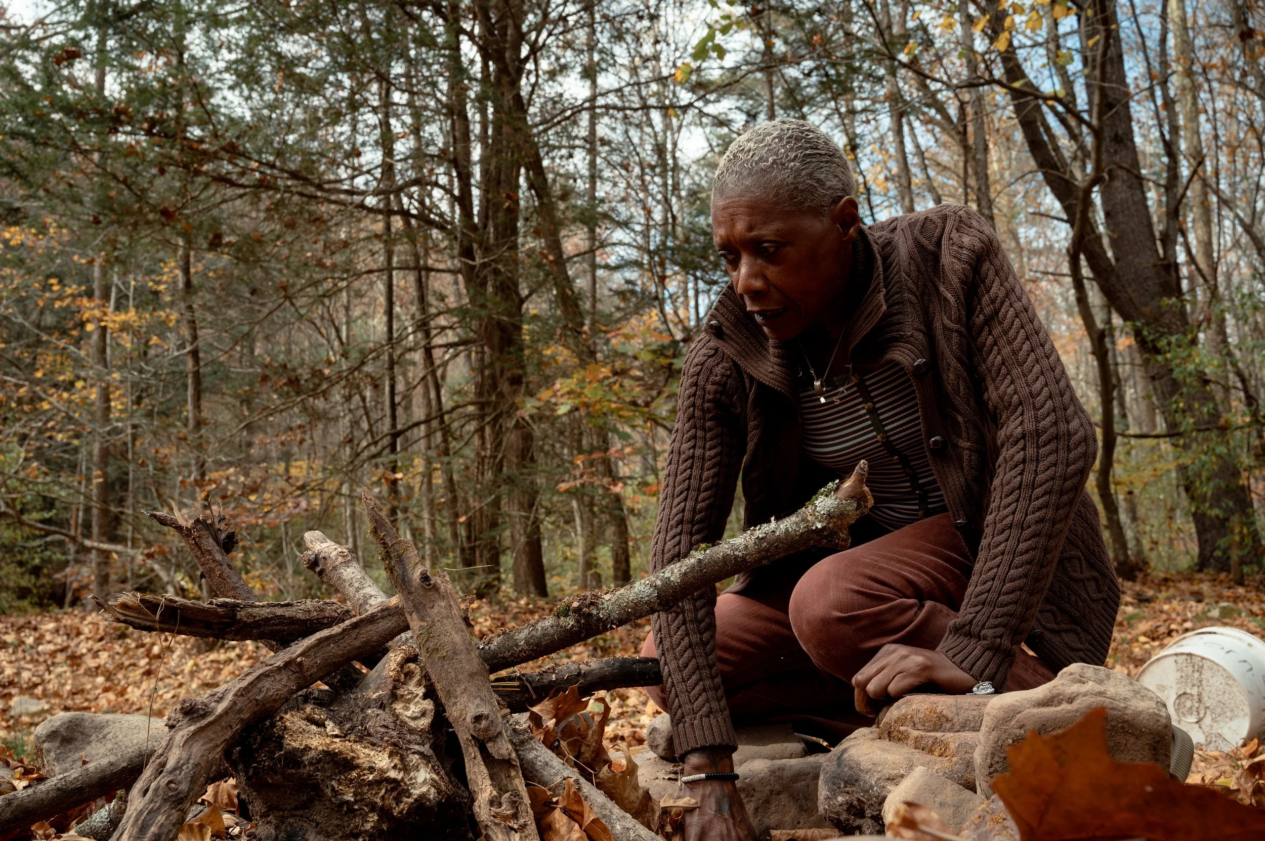 Spider digs through a fire at her campsite in the George Washington National Forest. Spider splits her time between shelters and the campsite, where she said she feels happiest and most at peace.