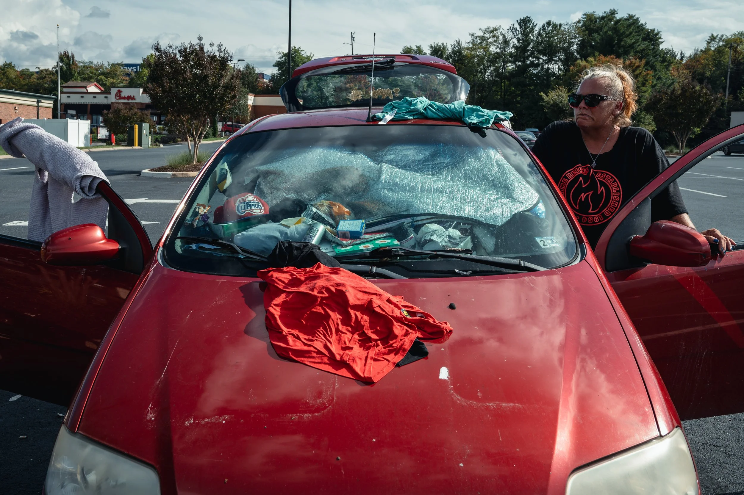 Heather sits outside the car she has called home for the past three years in Harrisonburg, Va. Recently laid off from her job at Tacos 4 Life, a restaurant that helps provide meals to people facing food insecurity, she now faces an uncertain future w