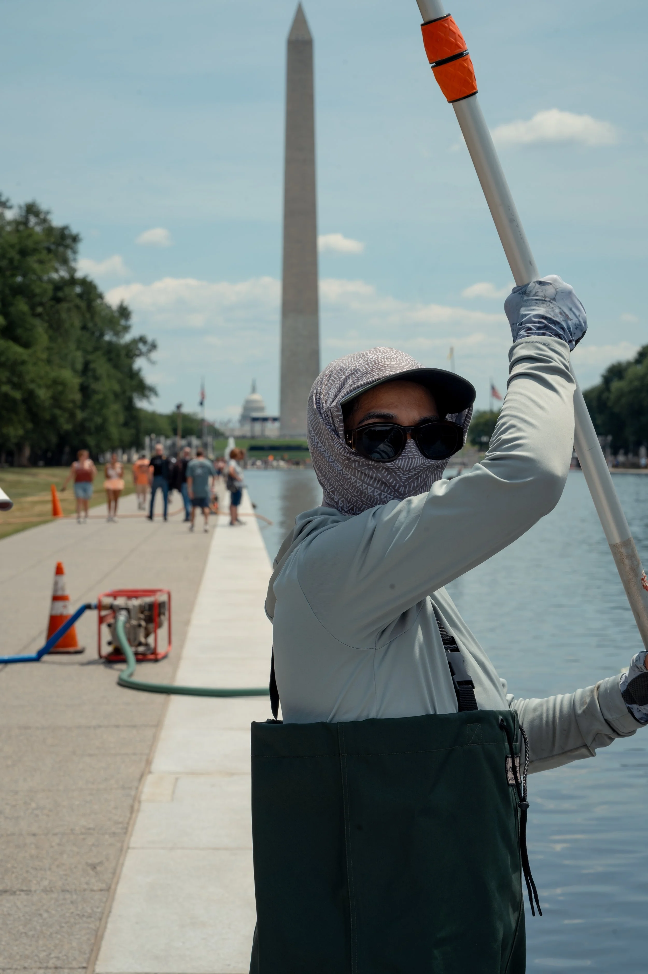 Heather, a contractor with the National Park Service, removes algae from the Reflecting Pool on the National Mall in Washington, D.C. The cleanup followed a major renovation project at the site.