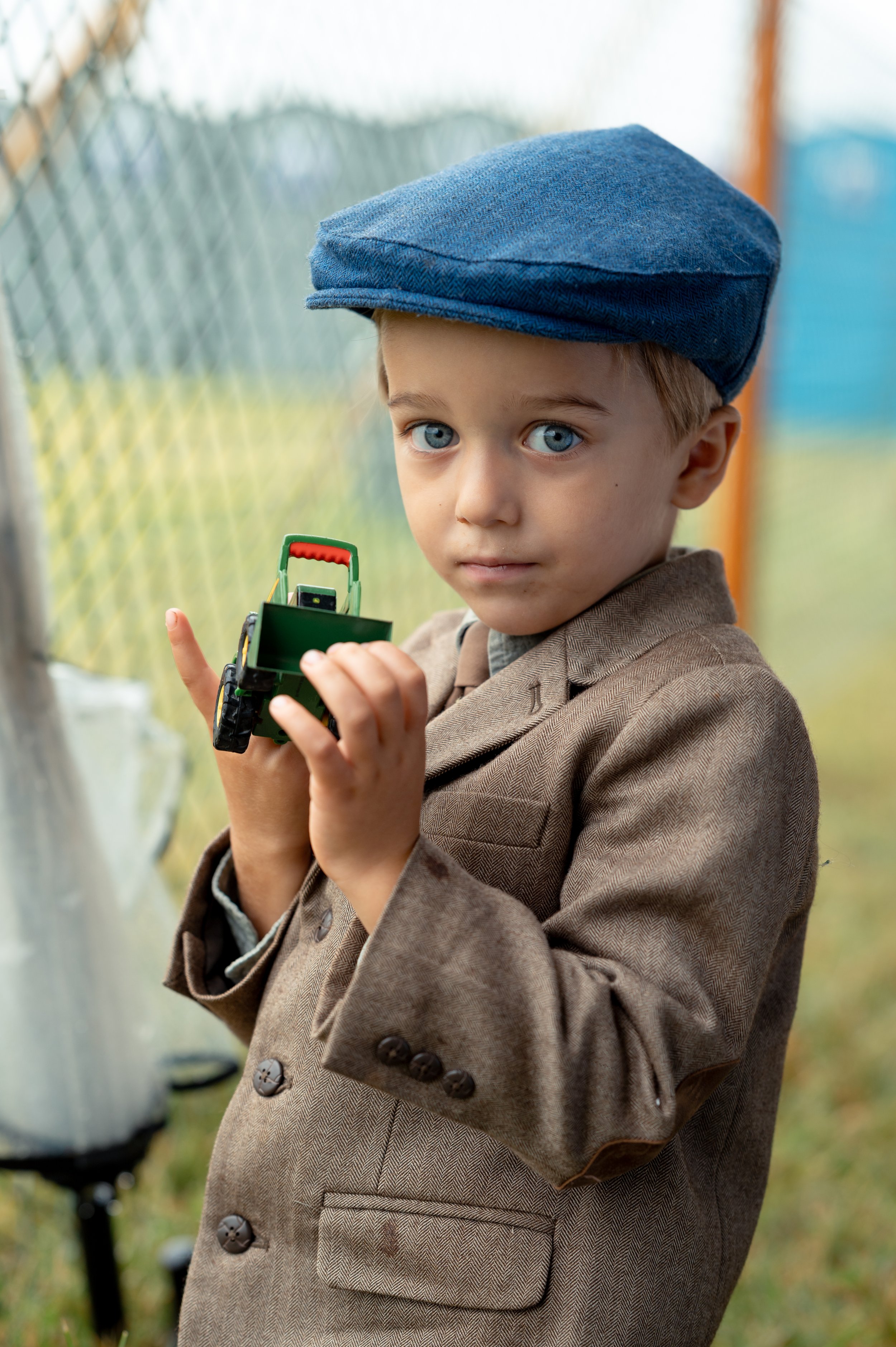 Benji, 3, plays with a green toy tractor in the children's tent as jockeys and horses prepare for the Foxfield Fall Races.