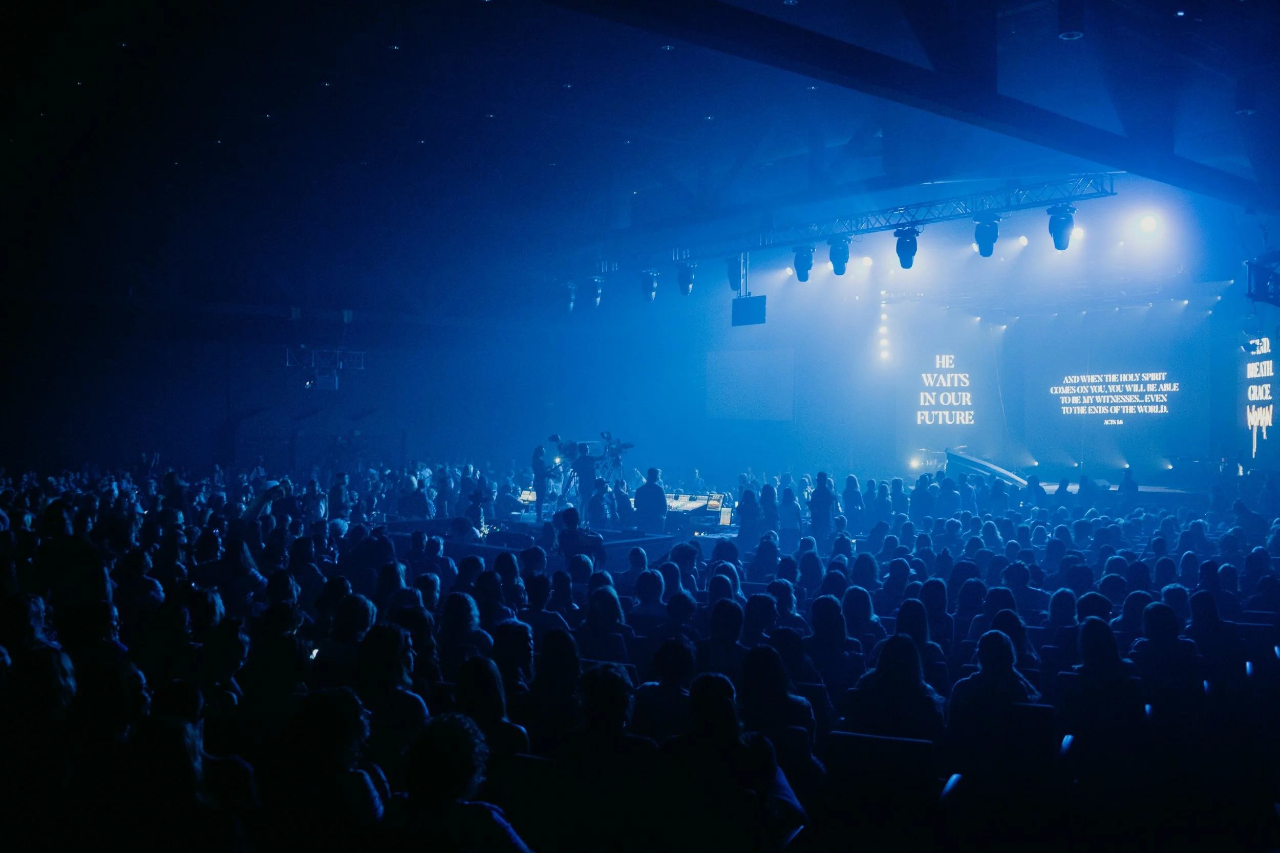 A large crowd of people attending an indoor concert or event