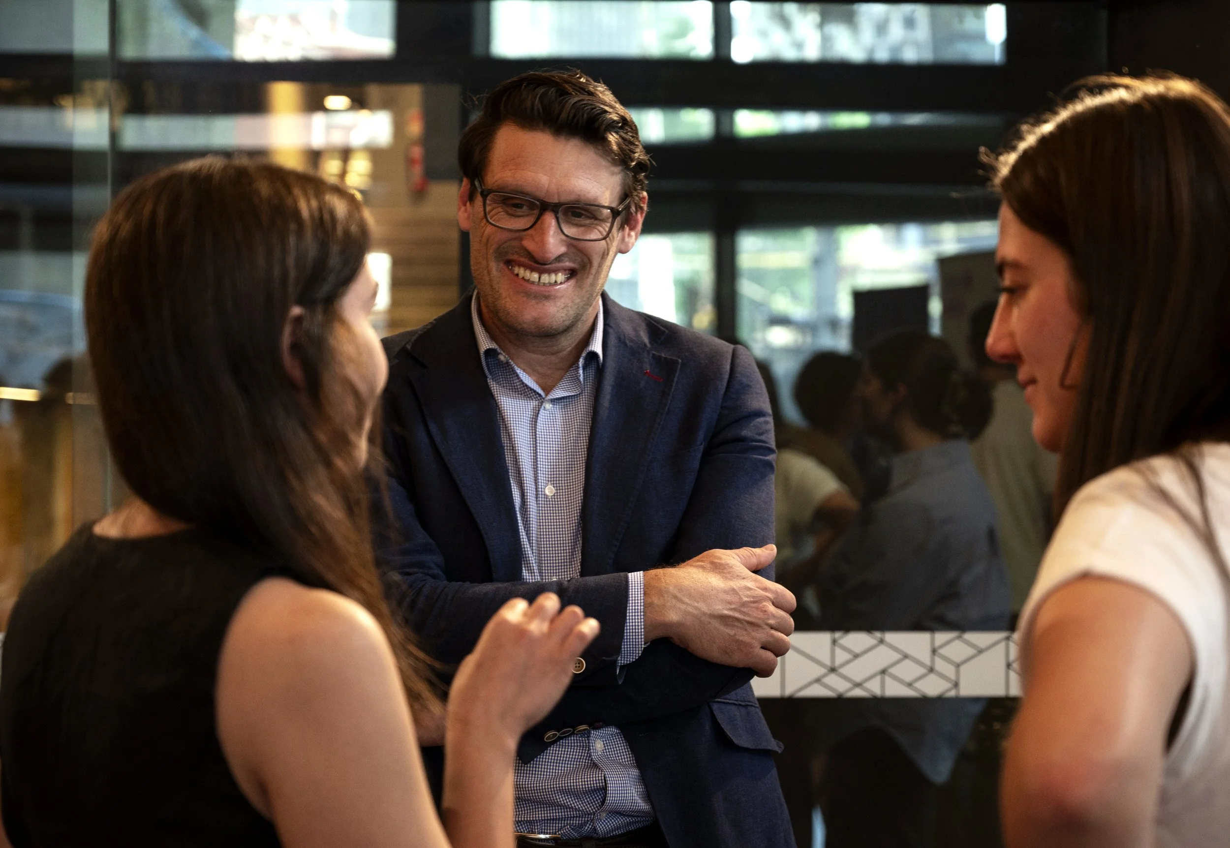 Attendees smiling and chatting at RMIT University event celebrating students.