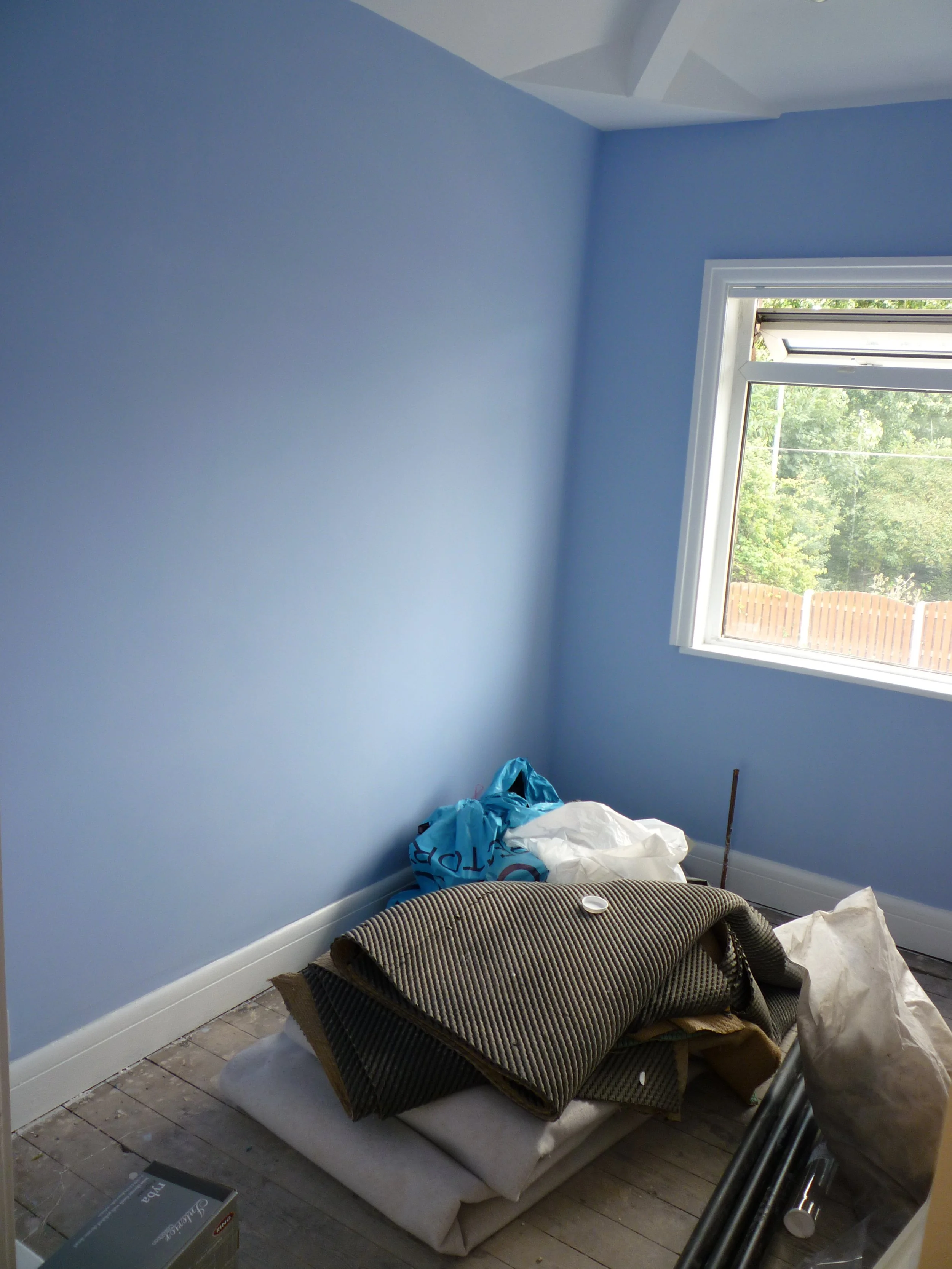 Side view of finished bedroom with blue painted walls