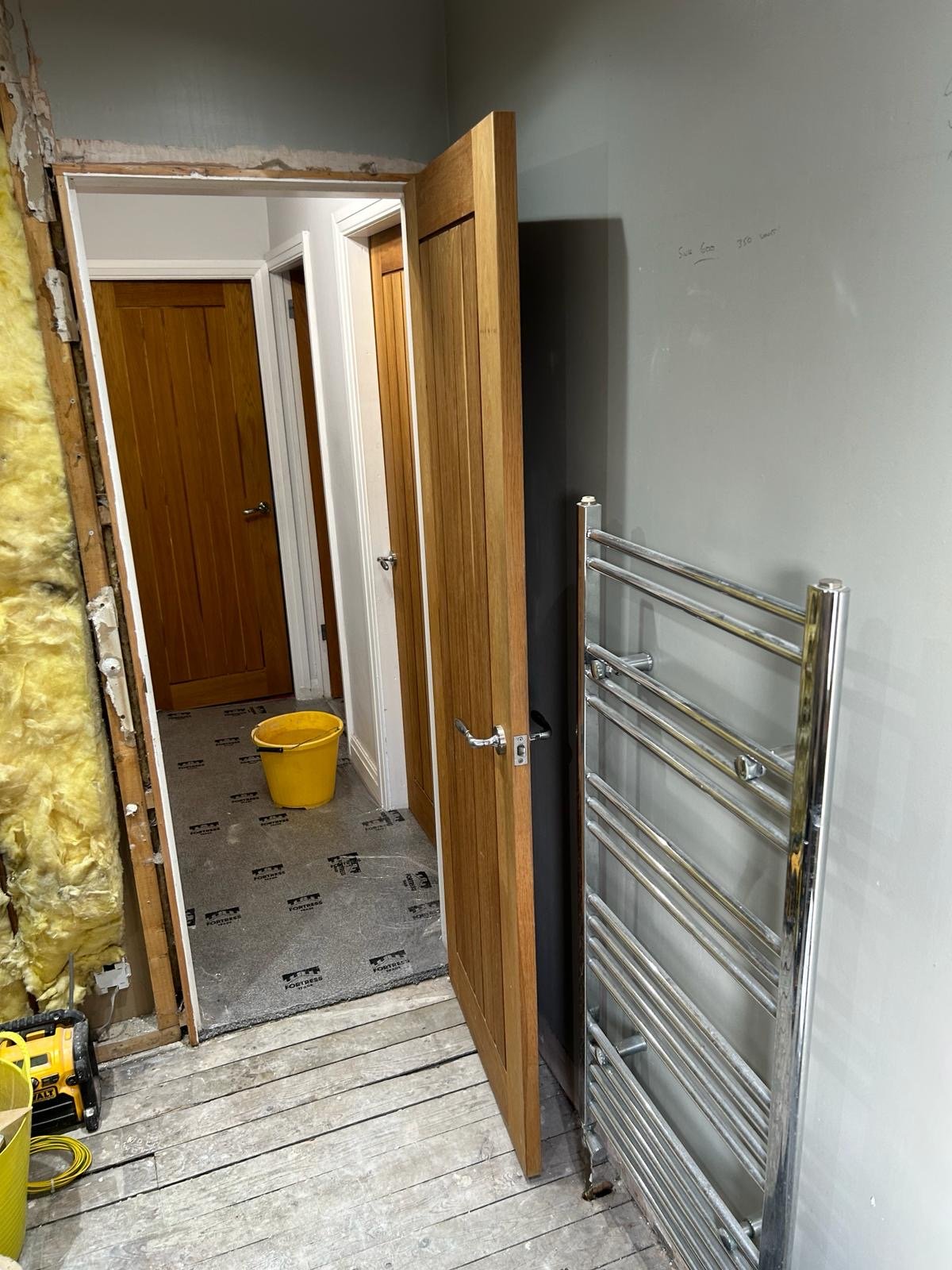 Mid renovation with exposed floorboards and shower stripped out