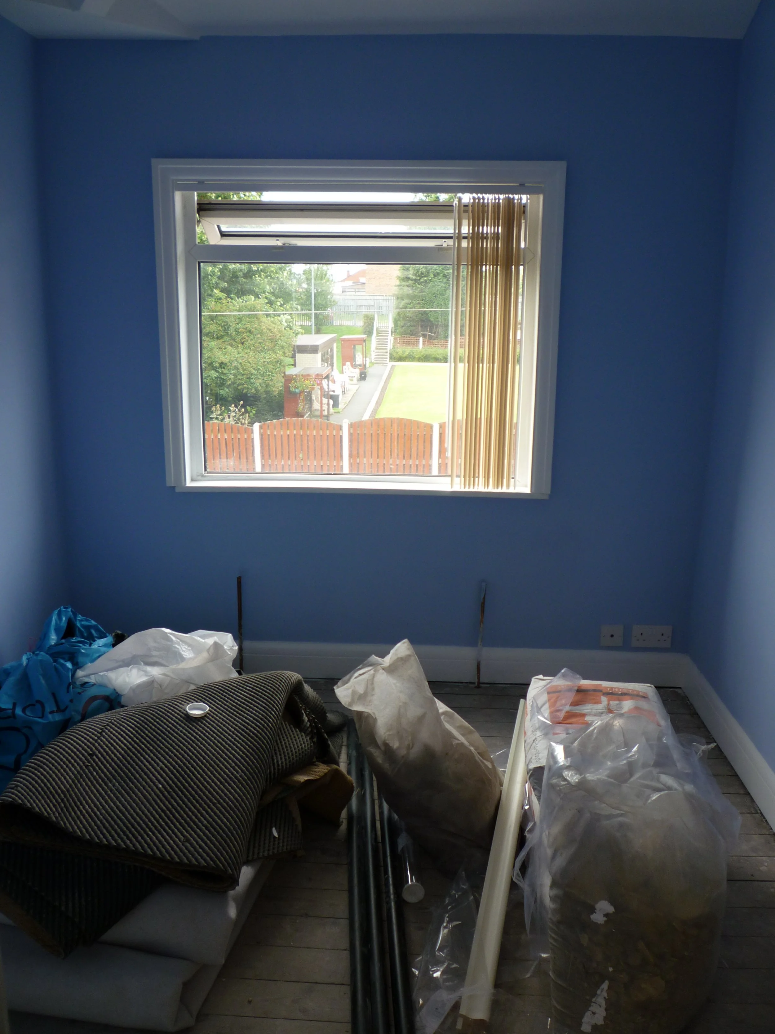 Front view of plastered bedroom with blue painted walls