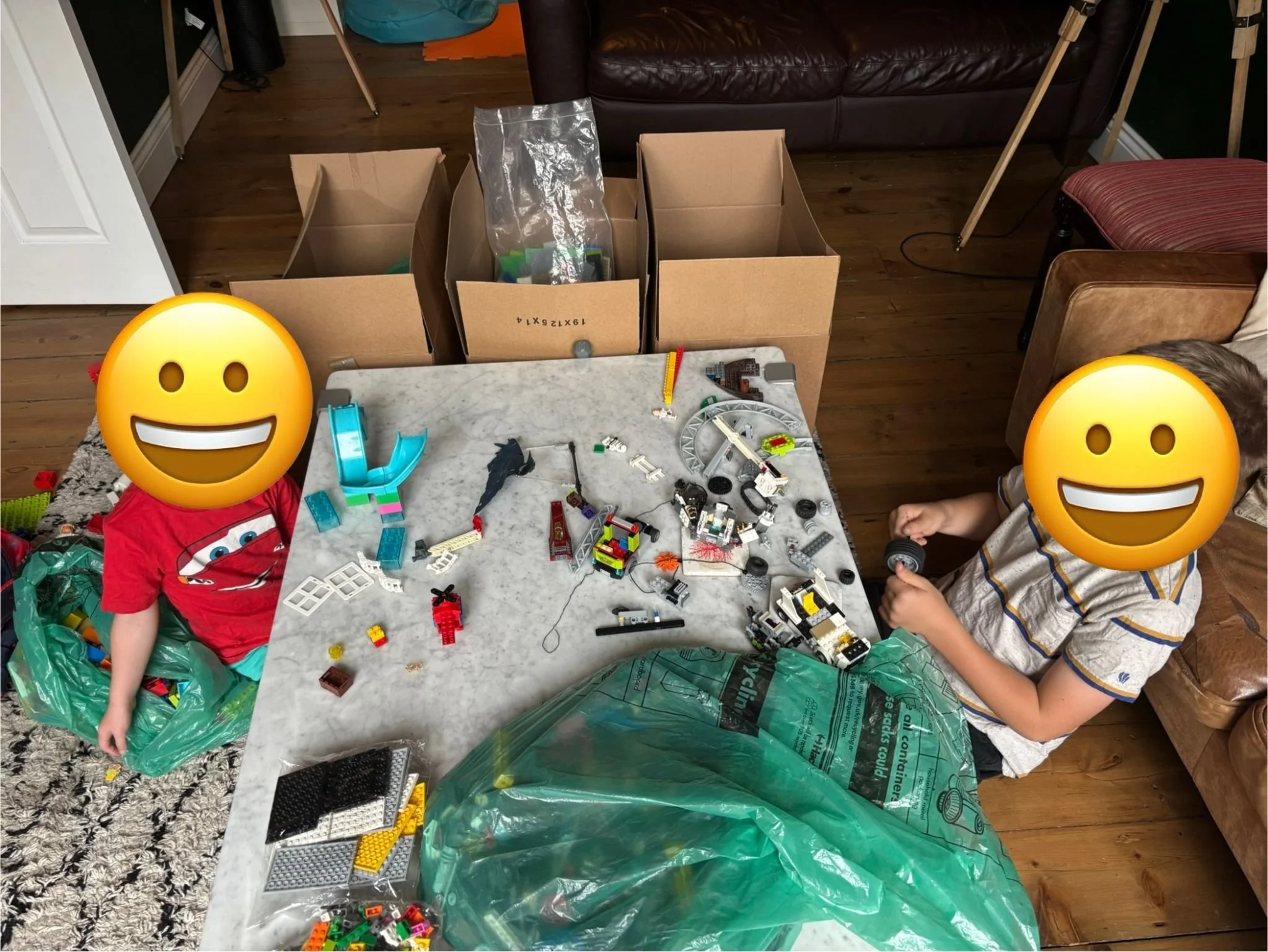 two children, faces hidden, play with LEGO