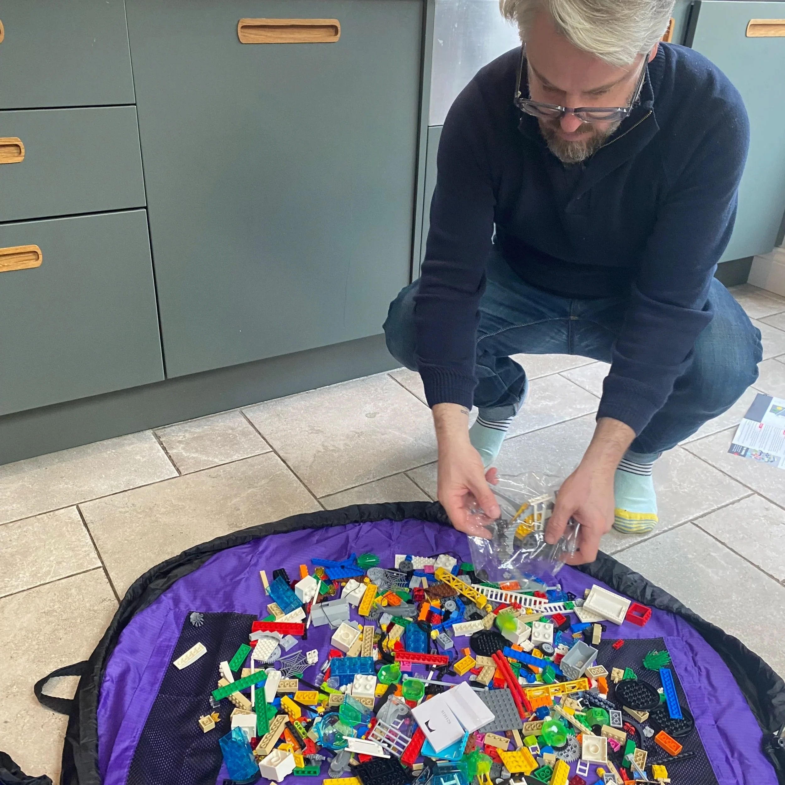 Aaron adds bricks to an open bag of LEGO®